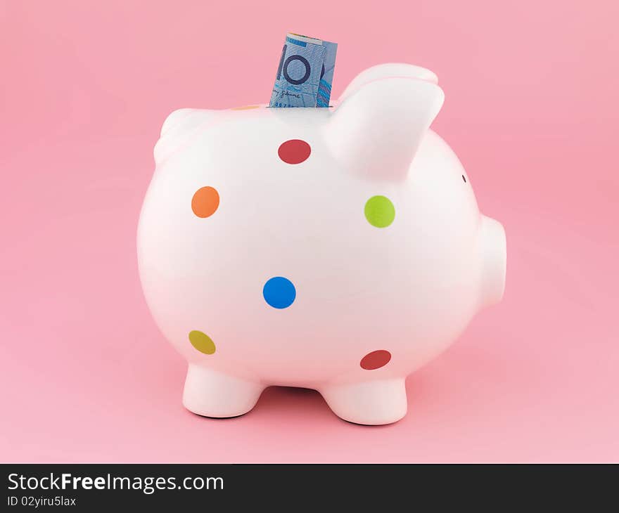 A piggy bank isolated against a pink background