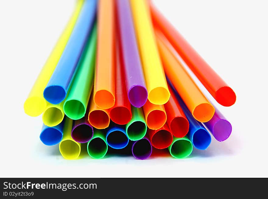 Several multicolored straws laying flat on a tabletop