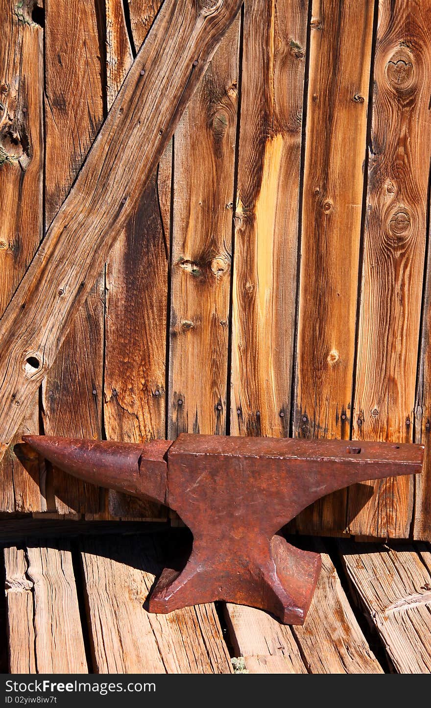 Old rustic Anvil with wooden wall background