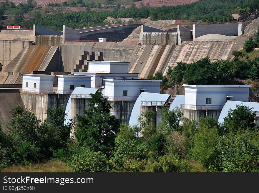 Water electricity plant, as big construction made by concrete built beside river, composed by different part.