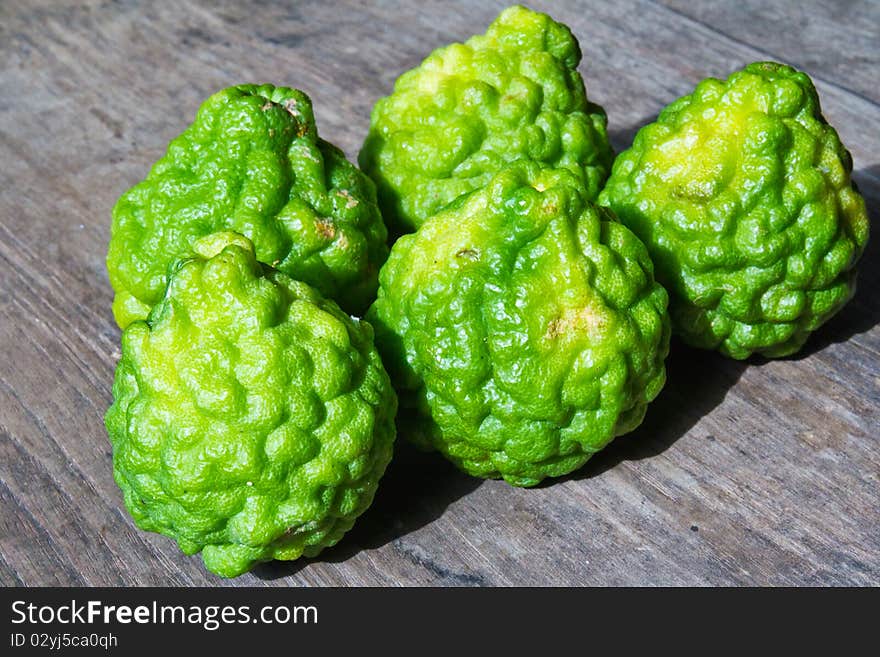 Green limes on wooden floor are herps for spa beauty and food ingredient.