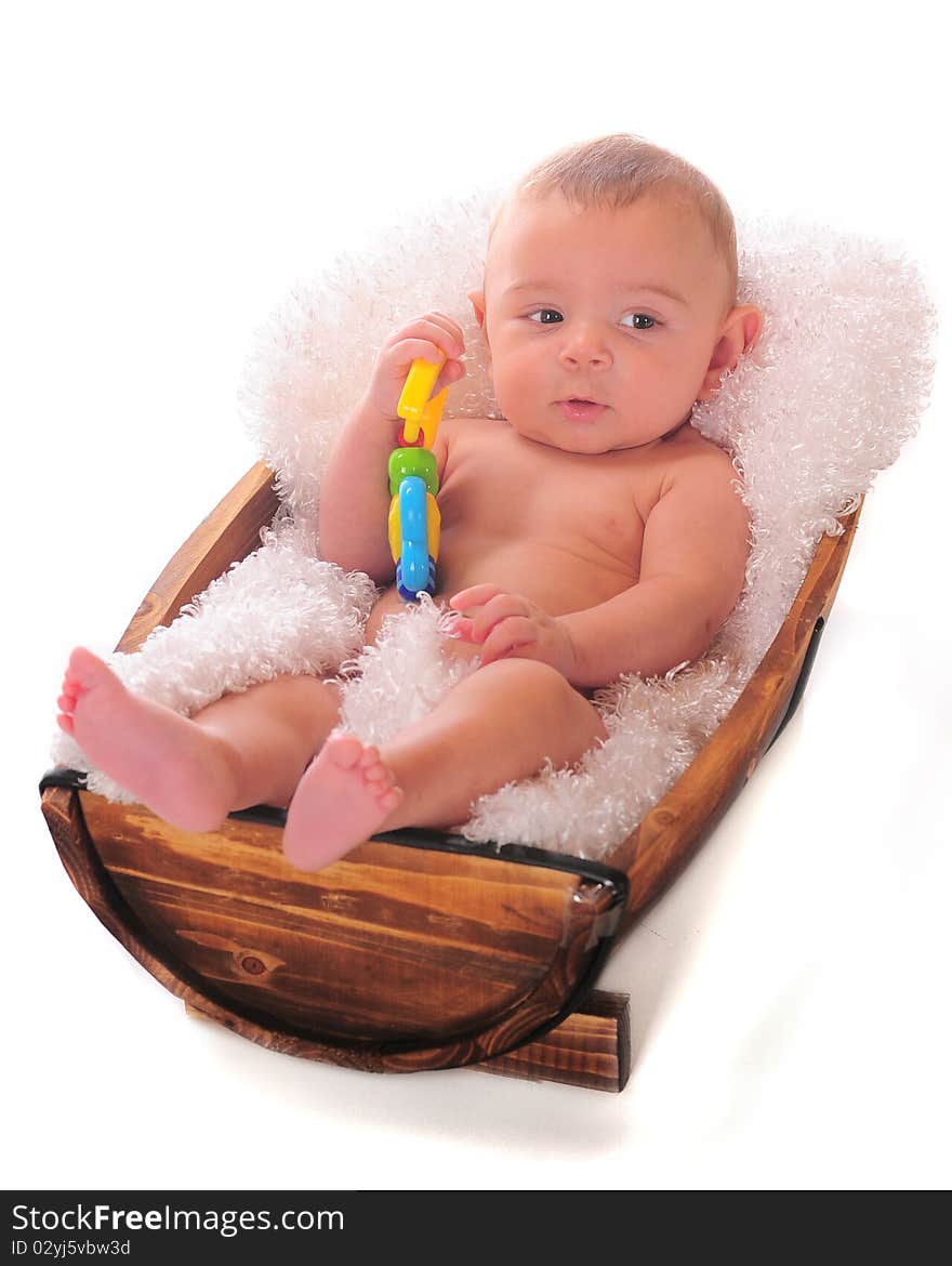 An adorable baby relaxing in a small fluff-lined half-barrel. He holds a toy in his hand. An adorable baby relaxing in a small fluff-lined half-barrel. He holds a toy in his hand.