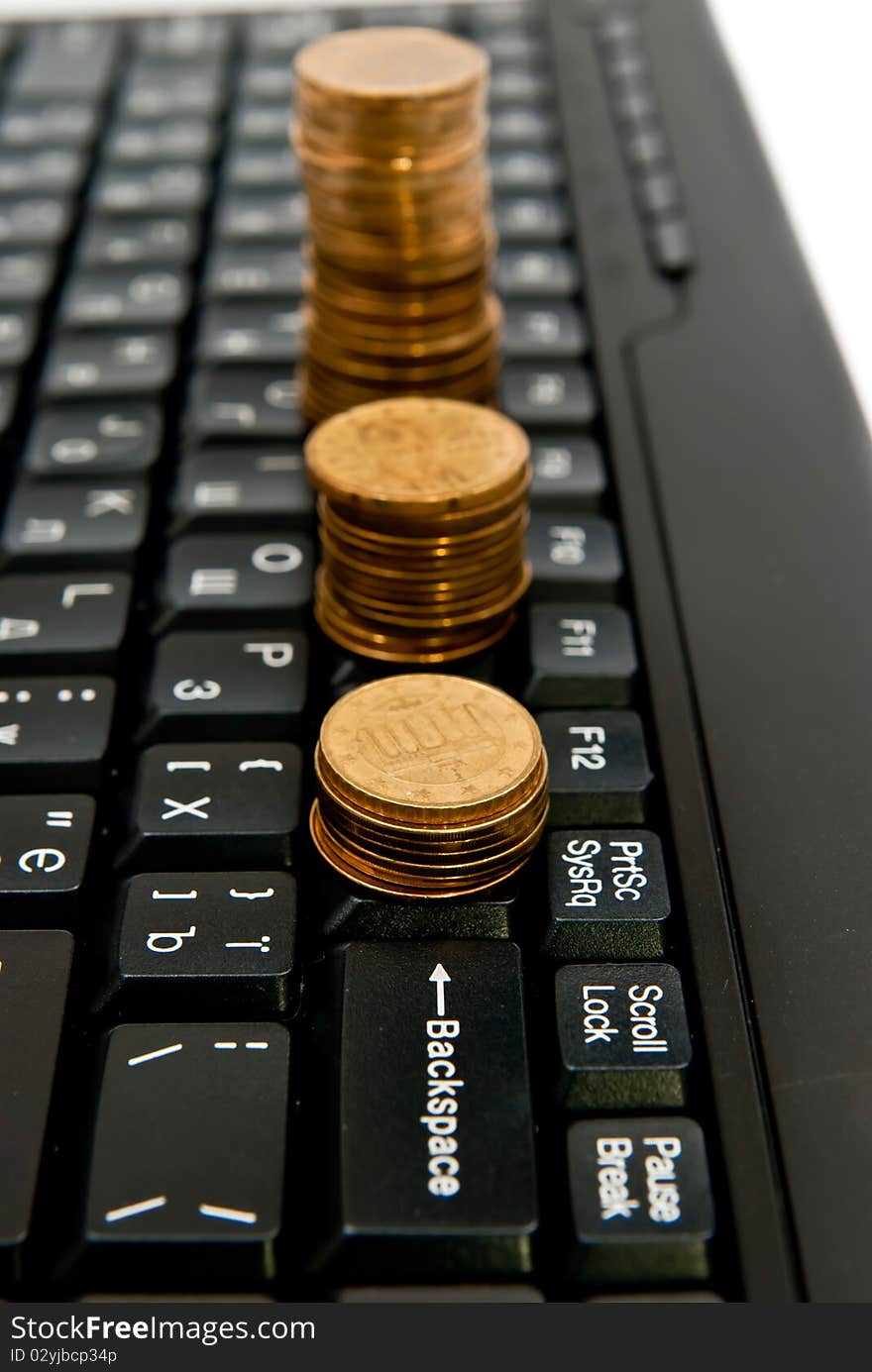 Line of coins on black computer keyboard. Line of coins on black computer keyboard