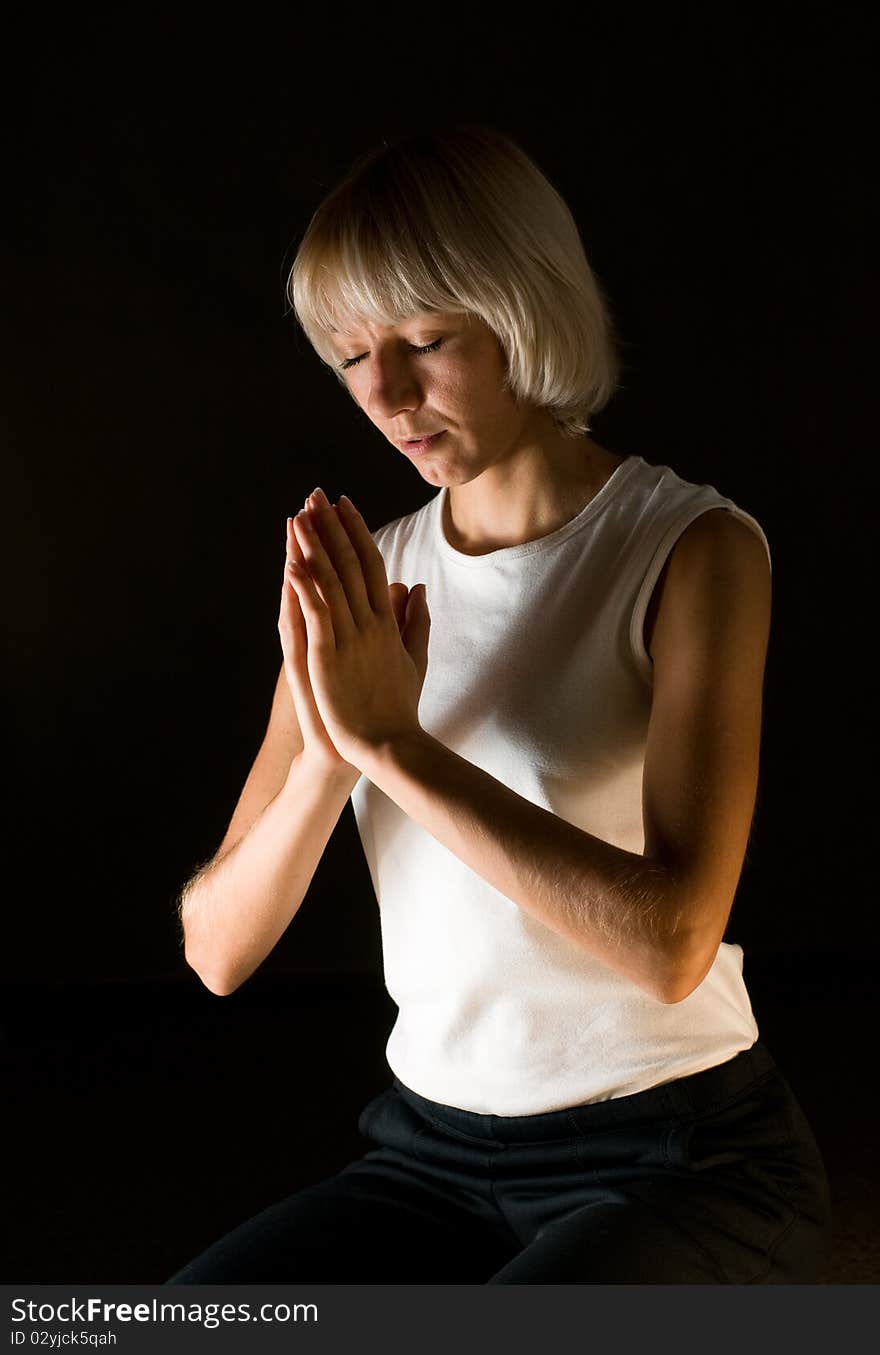 Woman praying on black background