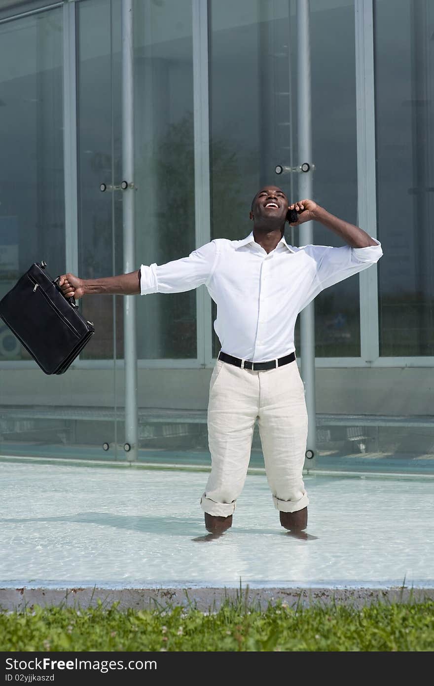 Businessman inside a pool receiving good news while on the phone. Businessman inside a pool receiving good news while on the phone