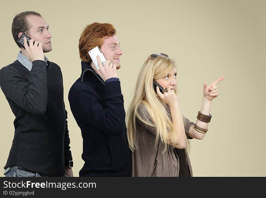 Two men and one woman calling by phone in office. Two men and one woman calling by phone in office