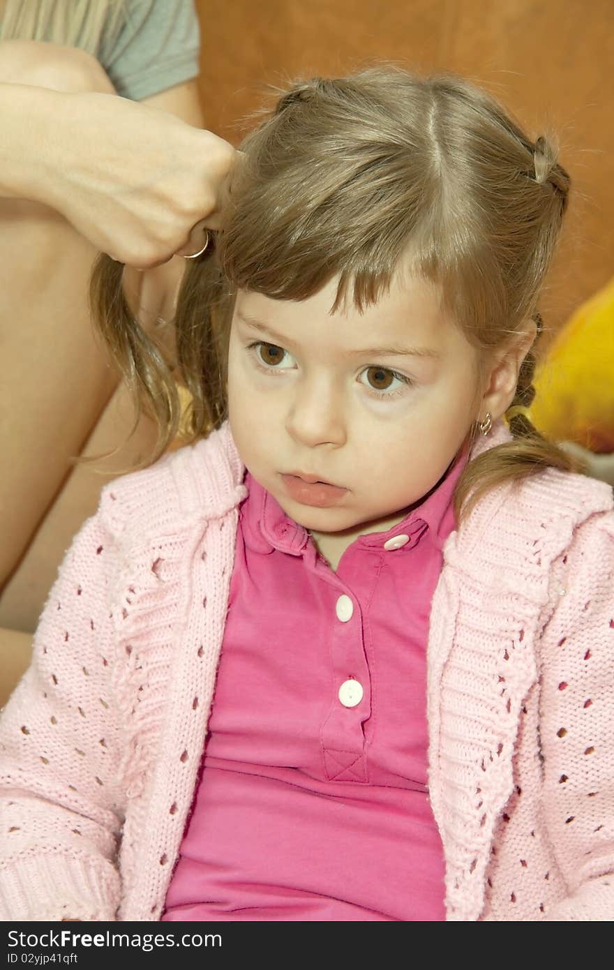 Mum does a hairdress to a daughter in the morning and the girl yawns. Mum does a hairdress to a daughter in the morning and the girl yawns