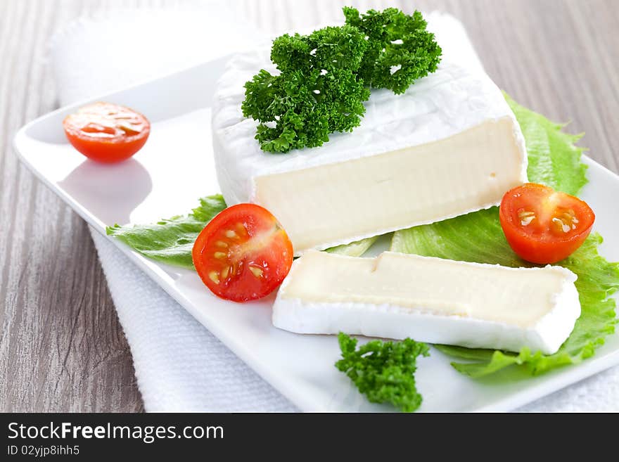 Camembert sliced on plate with tomato. Camembert sliced on plate with tomato