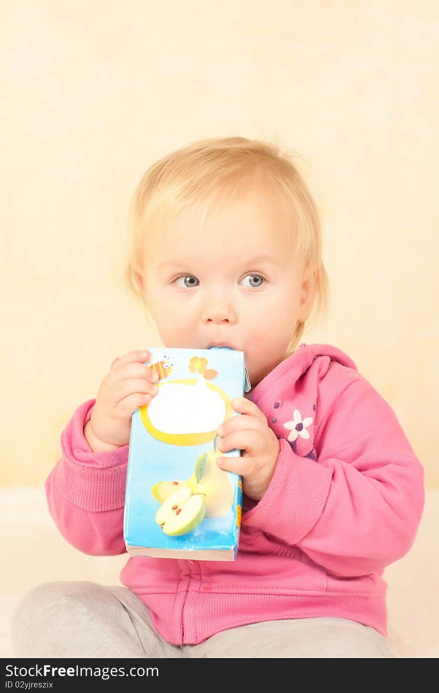 Cute toddler girl sit and drinking juice