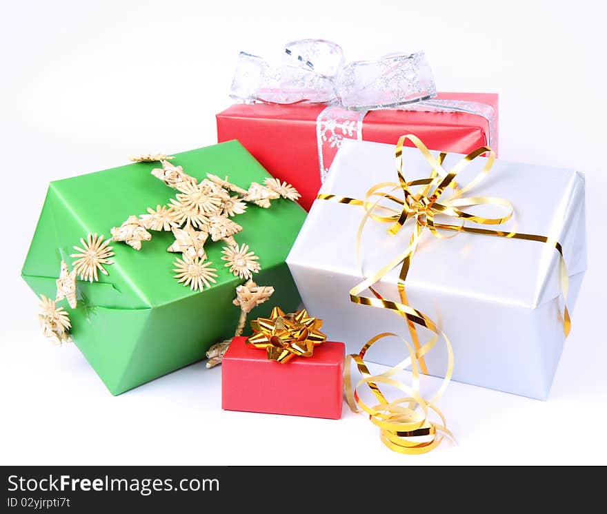 Gifts in silver, green and red wrapping with bows on white background. Gifts in silver, green and red wrapping with bows on white background