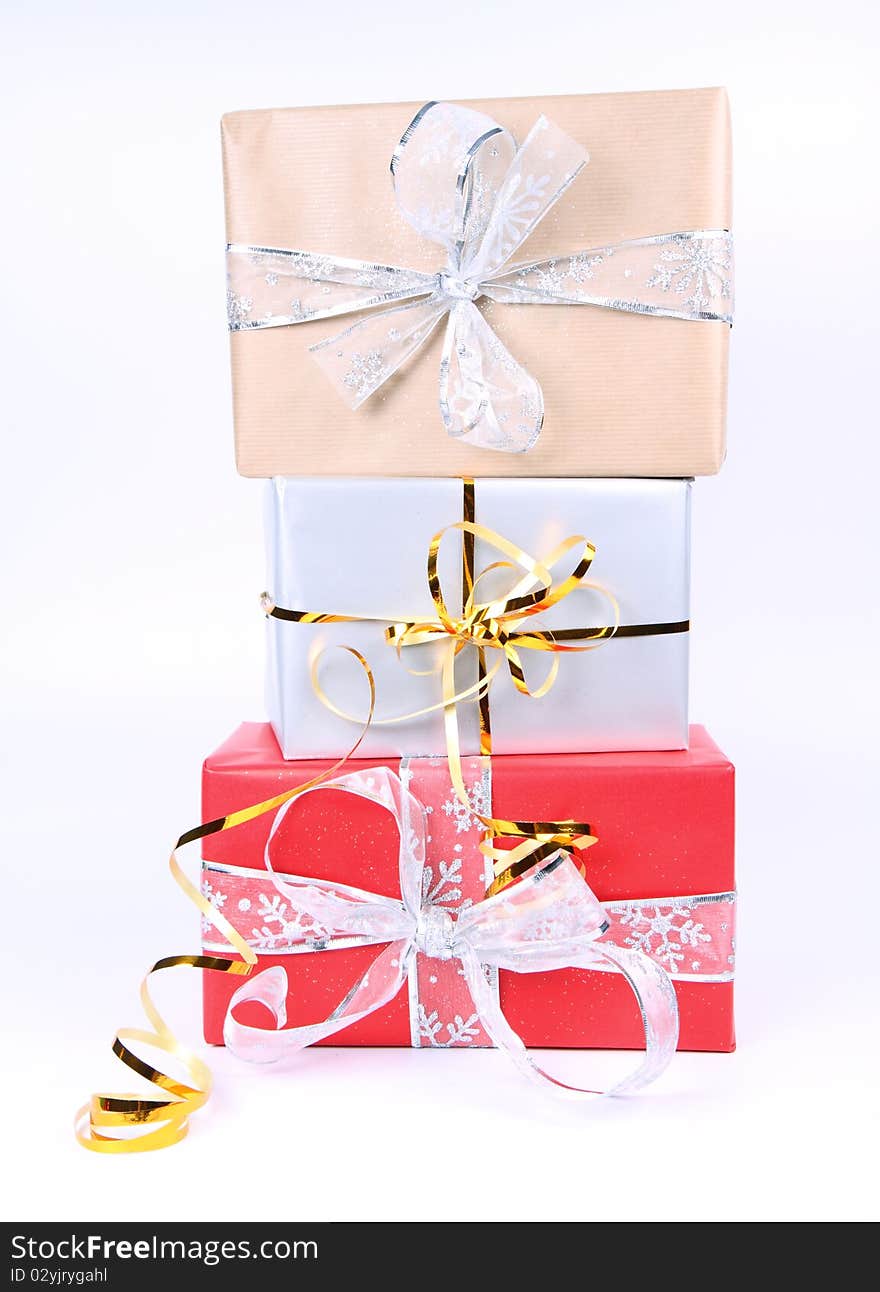 Gifts in silver, brown and red wrapping with bows on white background