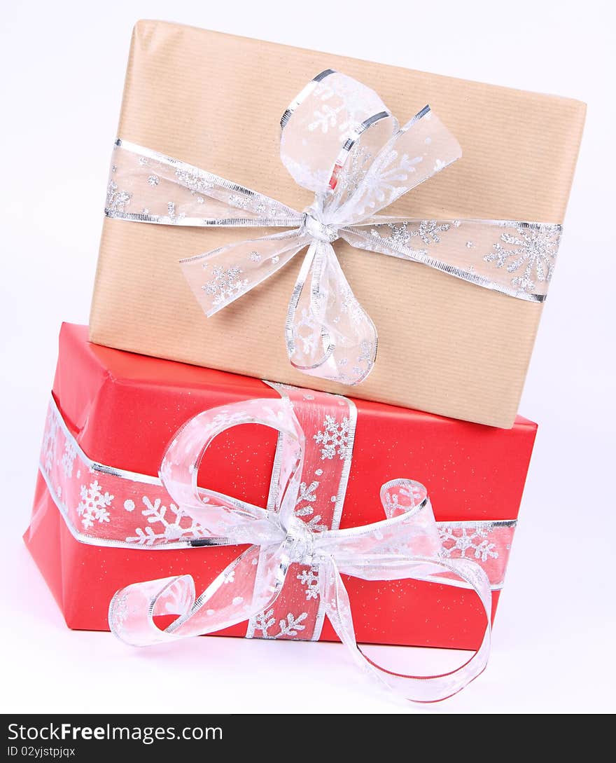 Gift in red and paper wrapping with silver bows on white background. Gift in red and paper wrapping with silver bows on white background