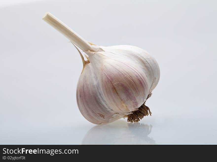 Clove garlic on a light gray background with a shadow, there is copyspace. Clove garlic on a light gray background with a shadow, there is copyspace