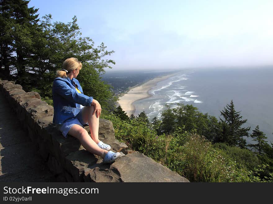 Sitting on a retaining wall and looking at the Oregon coastline on a foggy hazy day. Sitting on a retaining wall and looking at the Oregon coastline on a foggy hazy day.