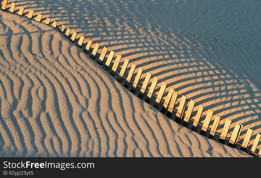 Fence and shadows on beach