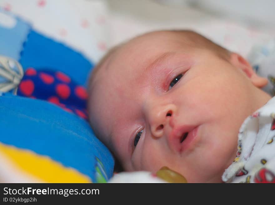 Photo of the beautiful baby lying on bed. Photo of the beautiful baby lying on bed