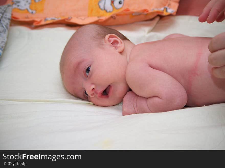 Photo of the beautiful baby lying on bed. Photo of the beautiful baby lying on bed