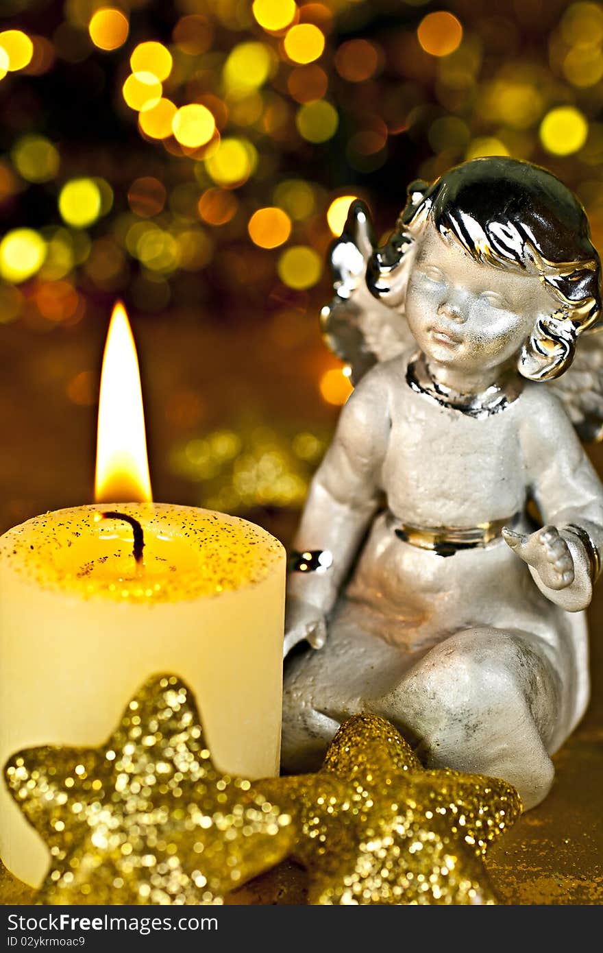 Christmas Angel staring at a burning candle. Rear Bokeh plan created by the filter. Christmas Angel staring at a burning candle. Rear Bokeh plan created by the filter