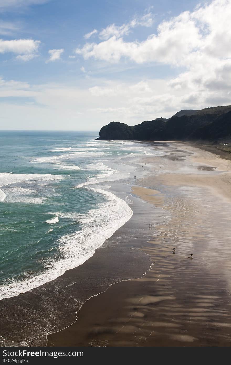 People and surfers walking on huge Beach, piha, new zealand. People and surfers walking on huge Beach, piha, new zealand