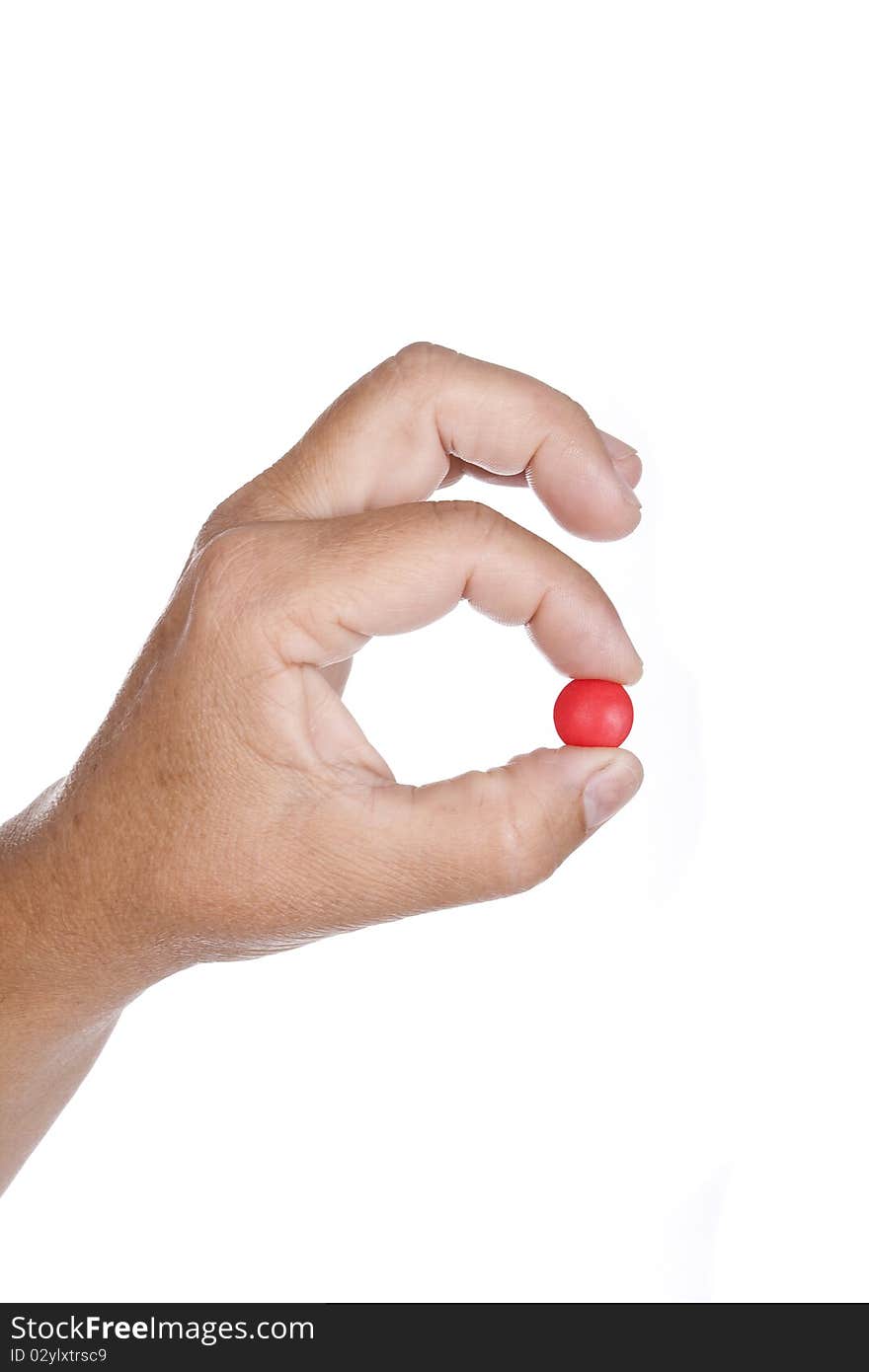 Hand is holding a red pill isolated on white background