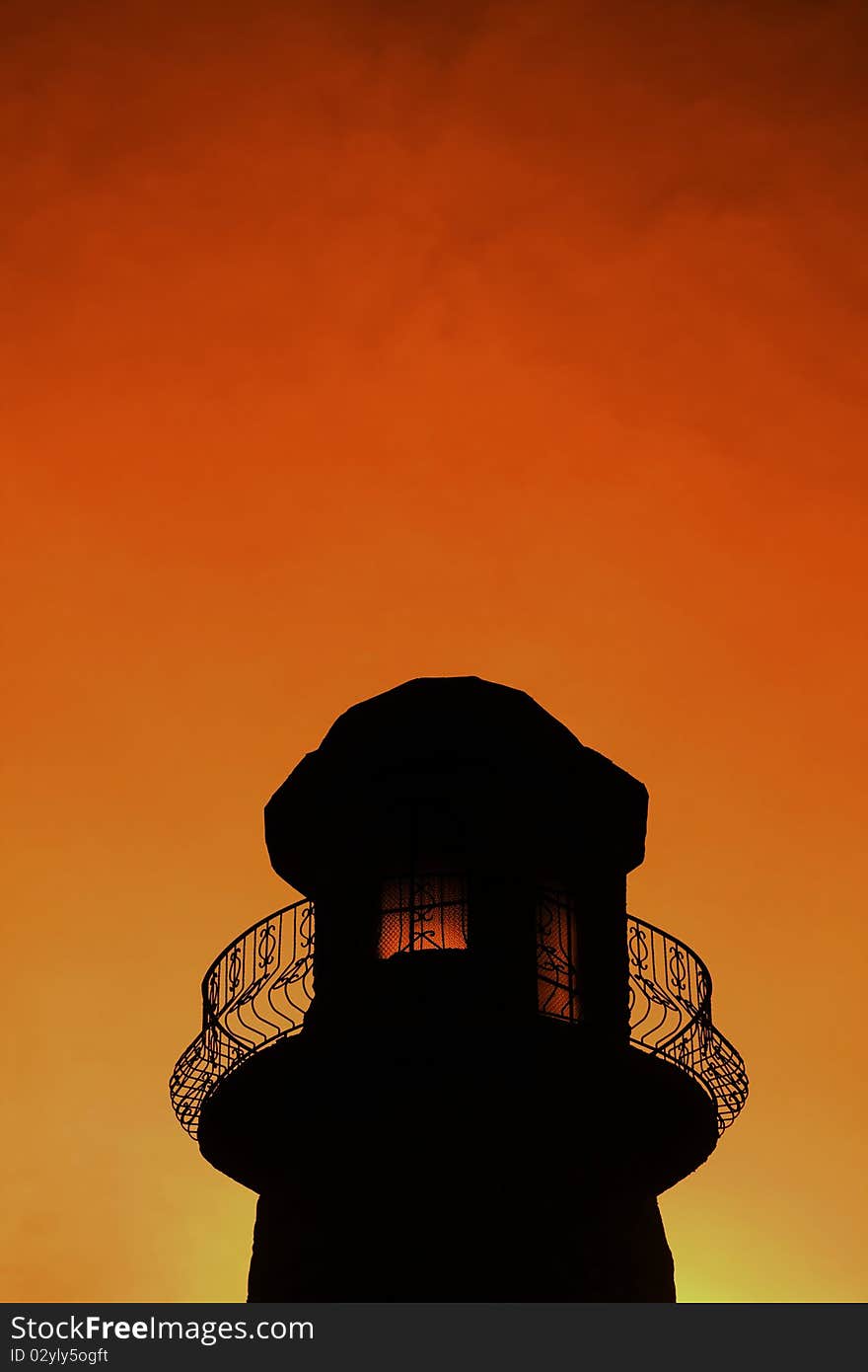 Silhouette of a lighthouse at sunset