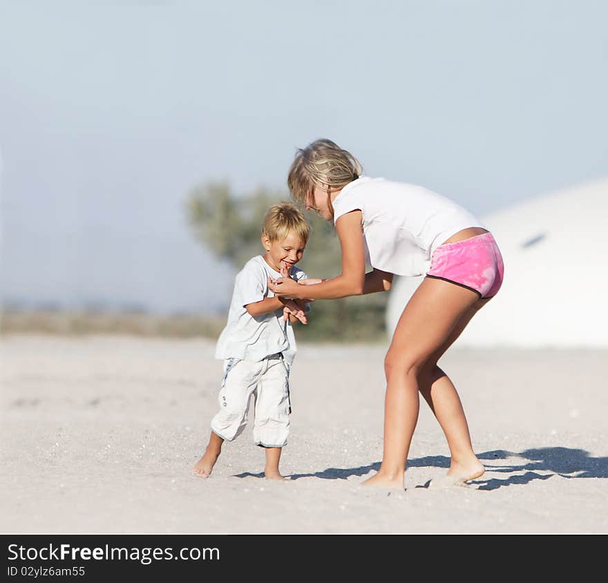 Happy mother and son playing on beach