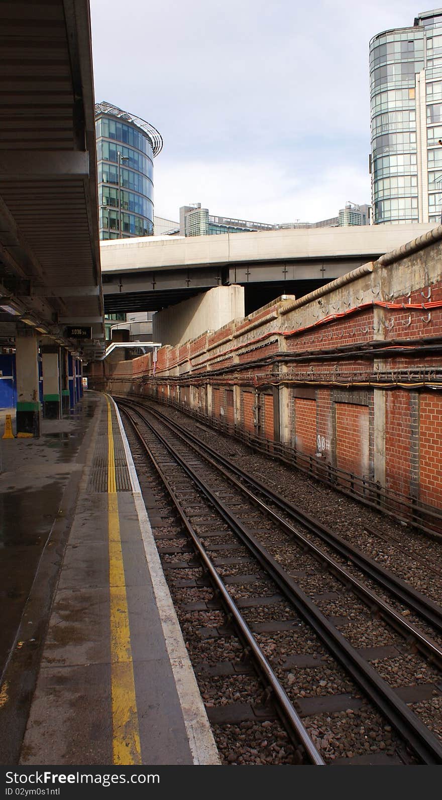 The tracks of the underground in london. this stop is on the surface and can be seen in the background the buildings of the city. The tracks of the underground in london. this stop is on the surface and can be seen in the background the buildings of the city.