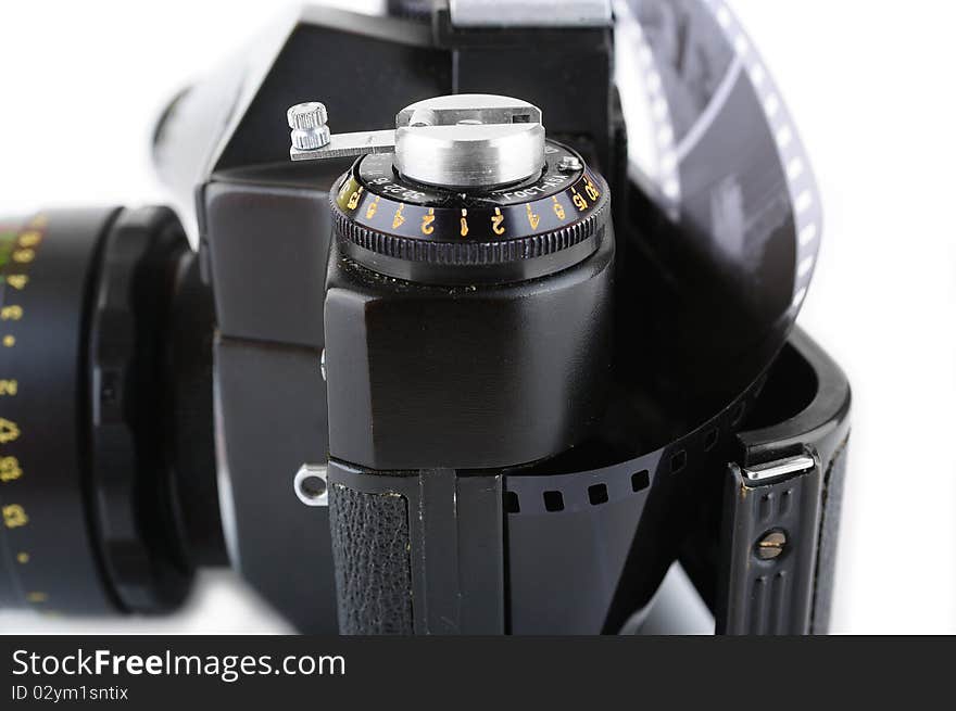 Close-up view of a opened classic manual SLR film camera with film on white background