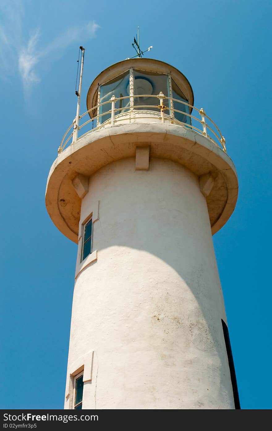 Marine white stone lighthouse in the sun against the blue sky. Marine white stone lighthouse in the sun against the blue sky