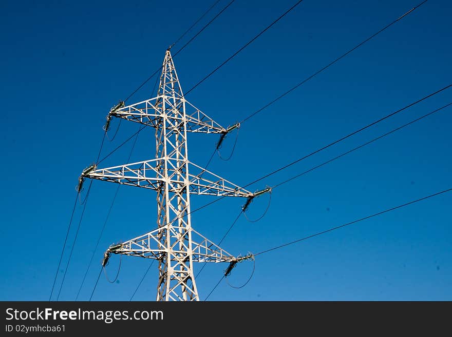 High voltage pylon against blue sky. High voltage pylon against blue sky