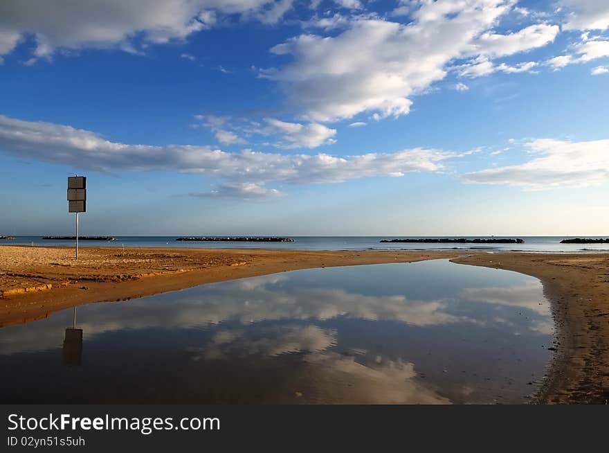 A sign on deserted beach in early morning of a bright sunny day. A sign on deserted beach in early morning of a bright sunny day