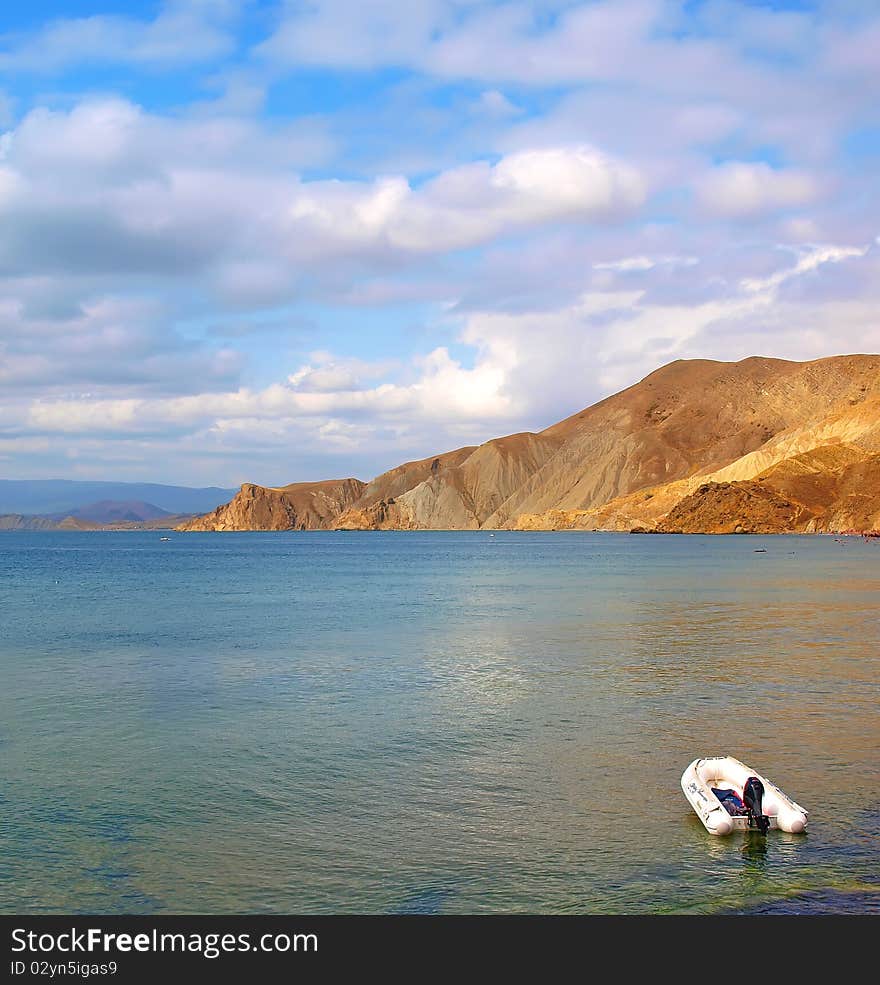 Motor boat at sea with mountains and sky