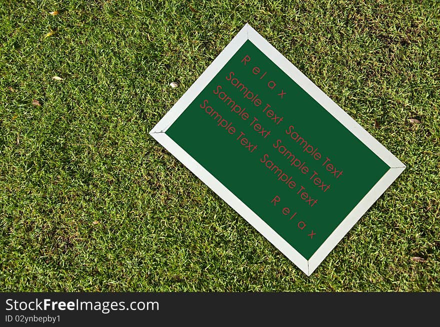 Chalkborad on green grass with sample text