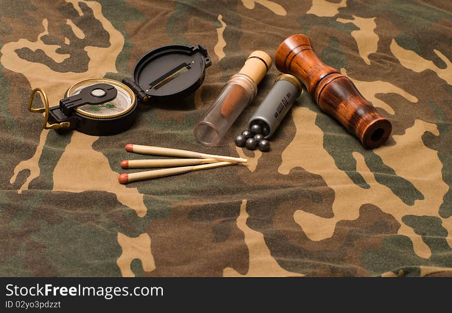 Subjects of the hunting ammunition on a camouflage fabric. Subjects of the hunting ammunition on a camouflage fabric.