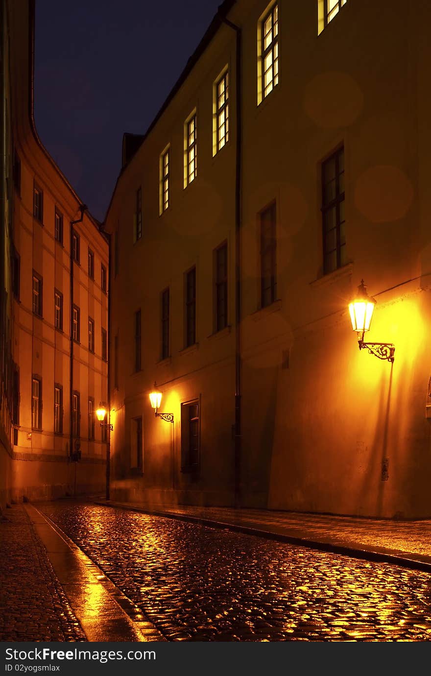 Old street in Prague, in rainy night with people shadows and light effects from drops. Old street in Prague, in rainy night with people shadows and light effects from drops.