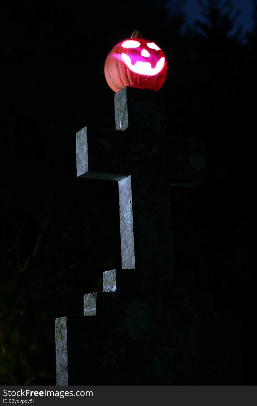 Pumpkin and gravestone at night