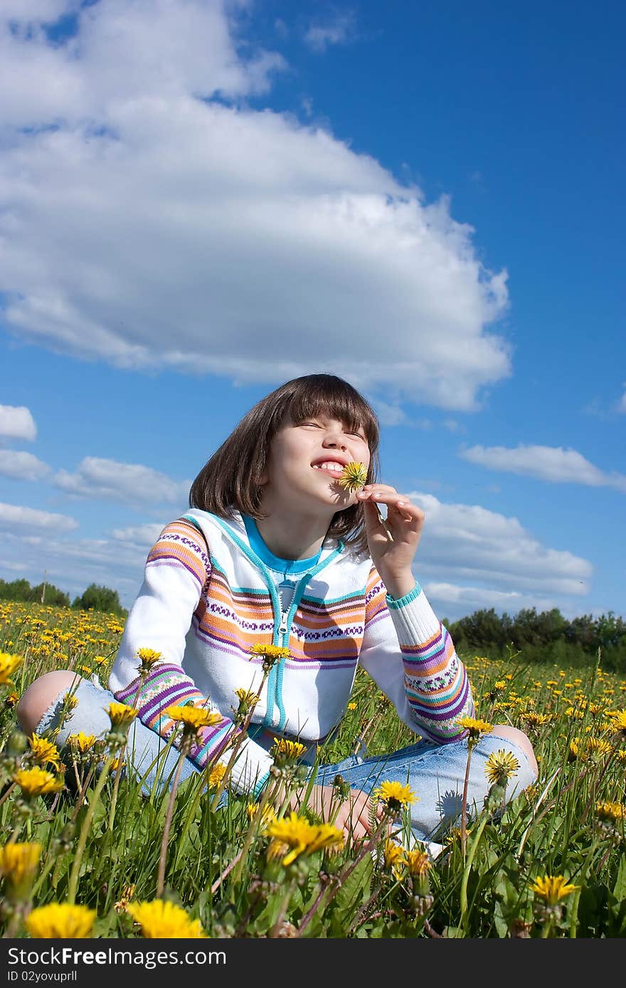 Little girl on the field with yellow daisies