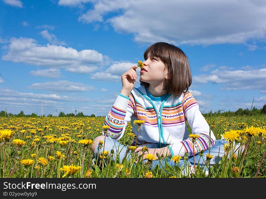 Little girl on the field with yellow daisies