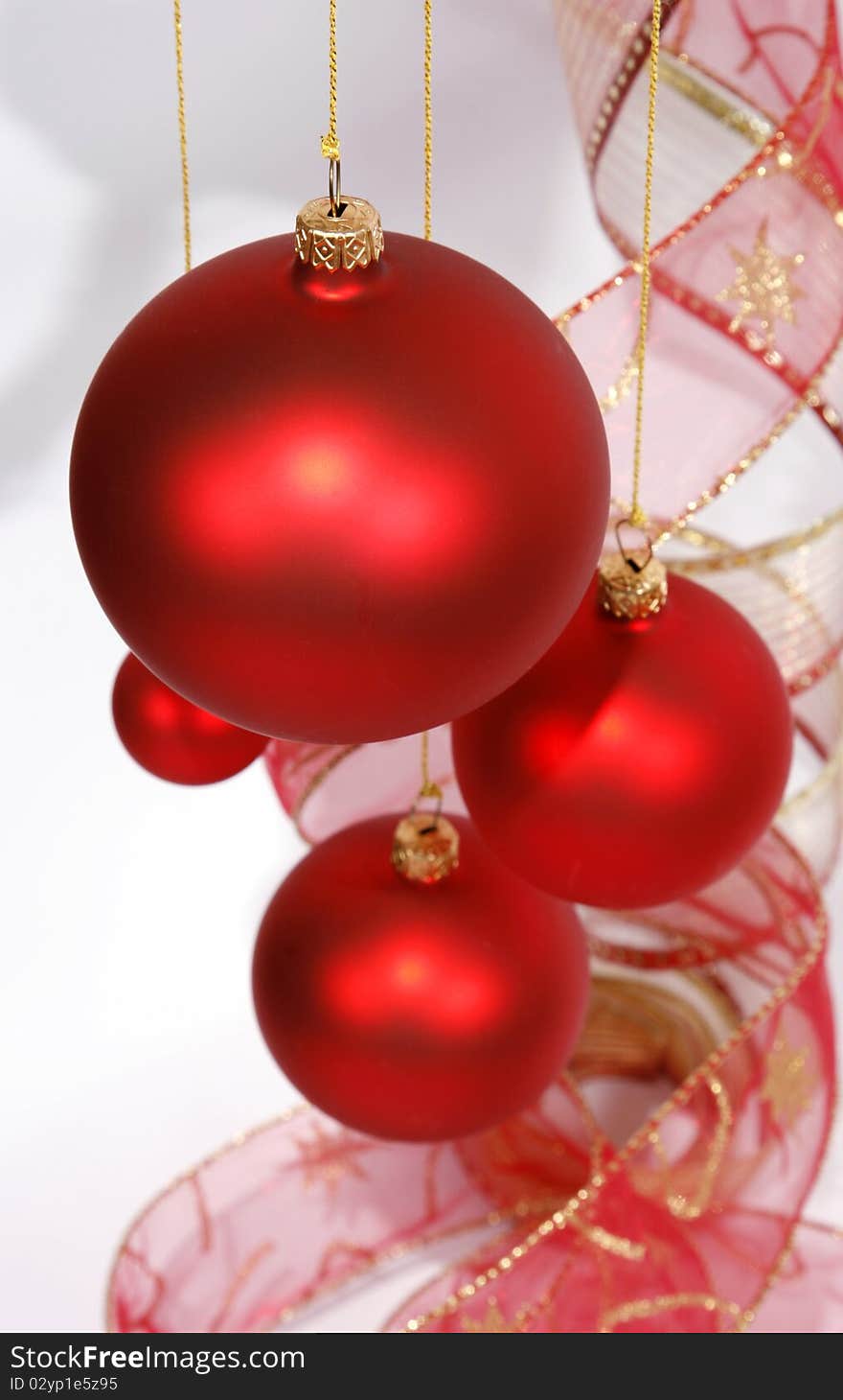 Hanging red glass balls with the ribbon on the white background. Hanging red glass balls with the ribbon on the white background