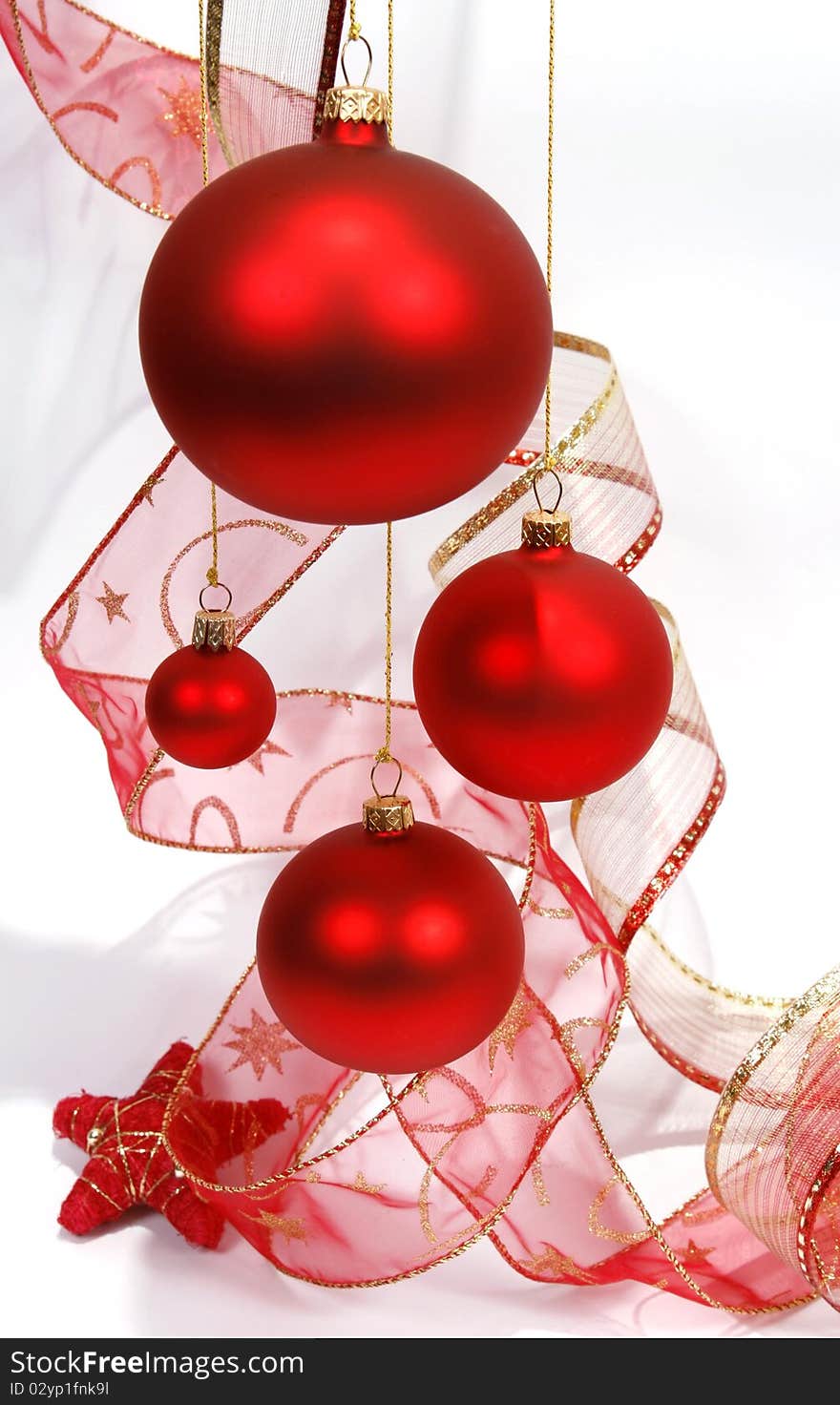 Hanging red glass balls with the ribbon on the white background. Hanging red glass balls with the ribbon on the white background