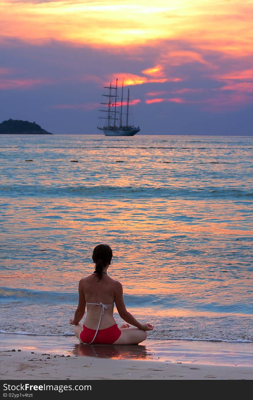 Woman meditating at the beach