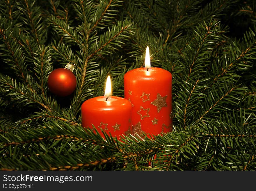 Two candles burning amongst twigs of the spruce. Two candles burning amongst twigs of the spruce