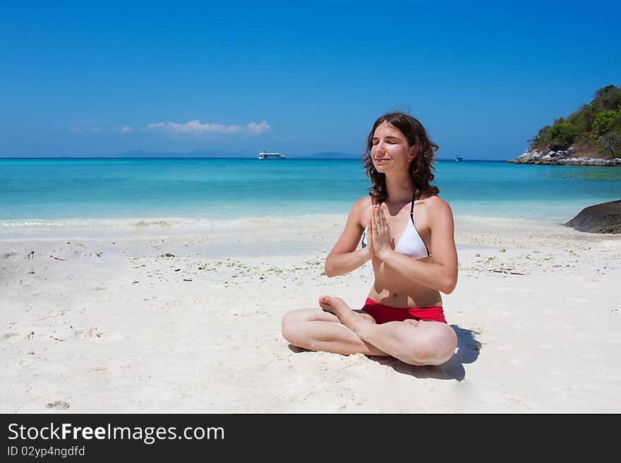 Woman meditating at the beach