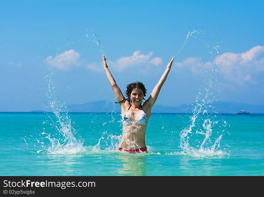 Young woman plays in water