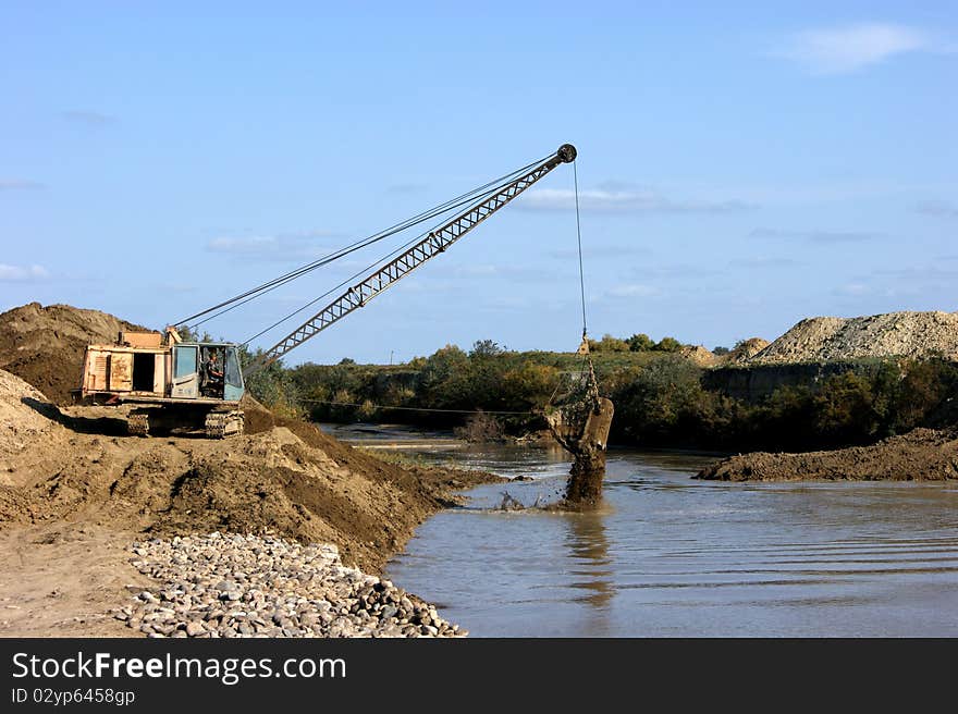 Construction of new seaport. Excavator on the workplace