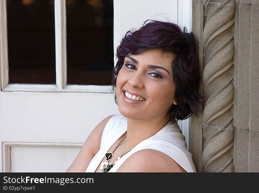 A smiling woman sitting in the doorway of an old building. A smiling woman sitting in the doorway of an old building.