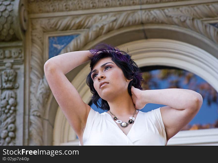 A woman posing in front of an old building. A woman posing in front of an old building.