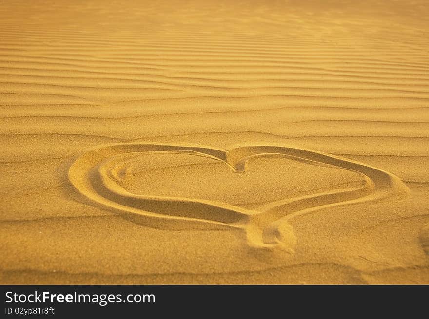 A photography of a heart in the sand. A photography of a heart in the sand