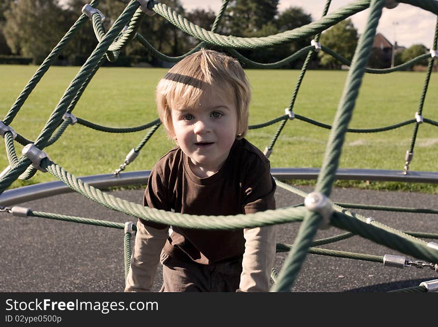 Cute blonde toddler age 3 playing in a playground. Cute blonde toddler age 3 playing in a playground