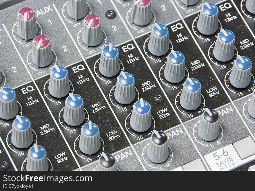 Close up image of an analog audio mixing board with several channels Dials and volume levels are visible. Close up image of an analog audio mixing board with several channels Dials and volume levels are visible.